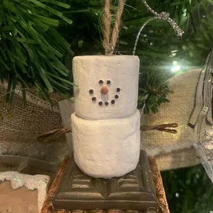 a snowman ornament hanging from a christmas tree