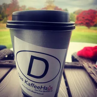 a cup of coffee on a picnic table