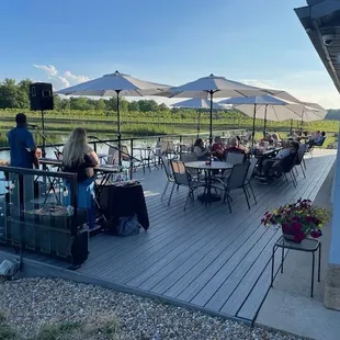 a group of people sitting at tables on a deck