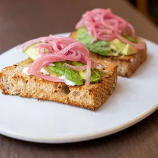 a sandwich with pickled onions and avocado