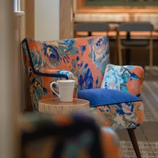 a colorful chair and a coffee cup