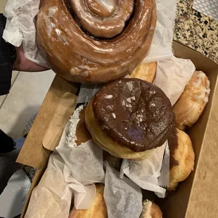 a person holding a box of donuts