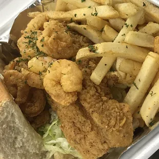 Dat po&apos;boy comes with fried fish and shrimp dressed on a soft French bread.