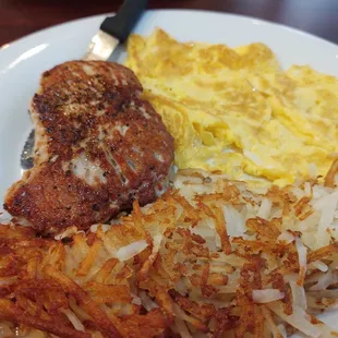 Grilled pork chop with scrambled eggs and hash browns