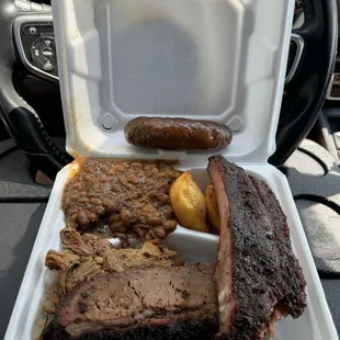 3 meat plate of brisket, ribs, pulled pork with smoked baked beans and cornbread $19.50 and an added sausage link $4.50