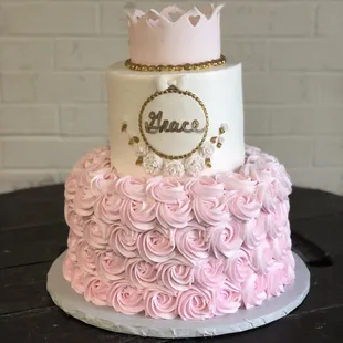 a pink and white cake with a crown on top