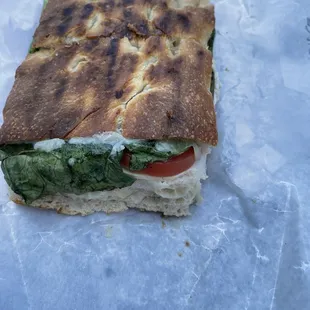 a sandwich with spinach and tomatoes