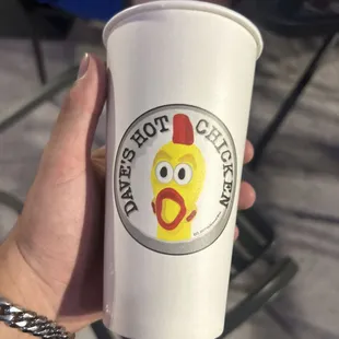 a hand holding a paper cup