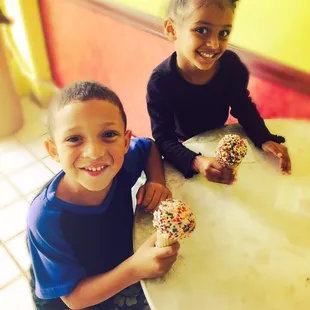 The enjoyed their chocolate and vanilla ice cream with rainbow sprinkles.