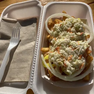 a sandwich and fries in a styrofoam container