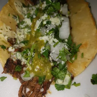 Smoked beef brisket seasoned with Dave&apos;s rub, topped with fresh onions, cilantro, cotija cheese and a creamy cilantro sauce