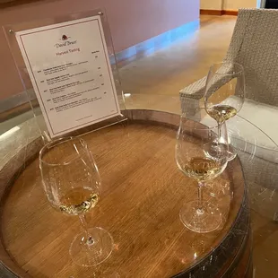 two glasses of wine on a barrel