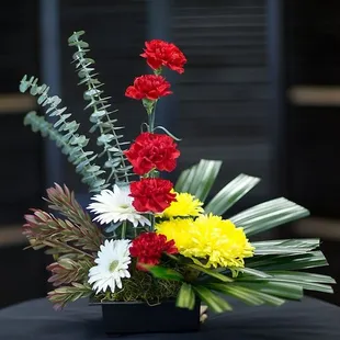 This modern design is memorable way to express sentiments. Flowers form a line of red with yellow and white finishing the des...