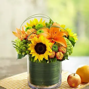 Arrangement of sunflowers, green mini hydrangeas, orange Asiatic lilies, orange spray roses, green hypericum, green button po...