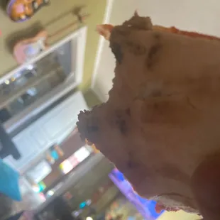 a hand holding a piece of pizza