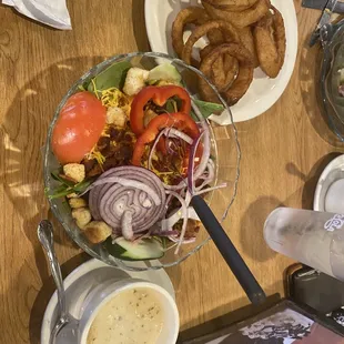 Spinach salad with hot bacon dressing served on the side.