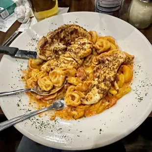 Tortellini over grilled chicken.