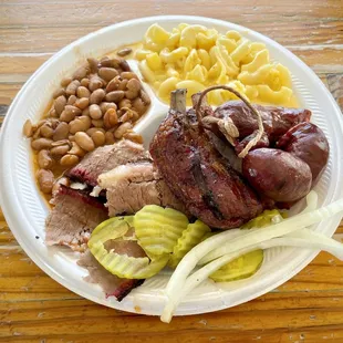 Three-meat plate with brisket, pork ribs, sausage, pinto beans, and macaroni and cheese