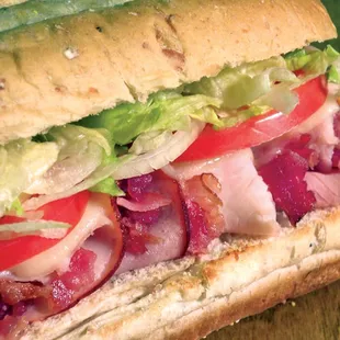 a sub sandwich with lettuce, tomato, and bacon