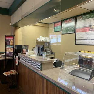a restaurant counter with a menu in the background