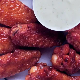 a plate of chicken wings with dipping sauce