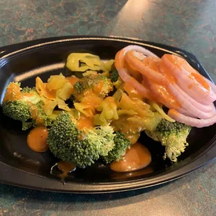 a plate of broccoli and onions