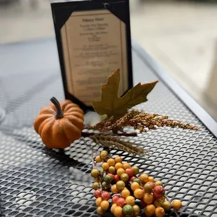 a table with a menu and a pumpkin