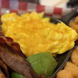 Breakfast platter, scrambled eggs with cheese. Crispy thick bacon