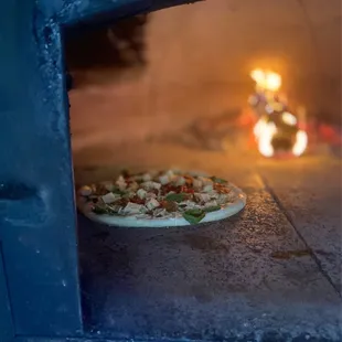a pizza cooking in an oven