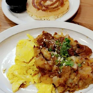 Chorizo Hash  potatoes sauteed with onions, peppers, and chorizo topped with two eggs any way, garnished with queso fresco and cilantro.