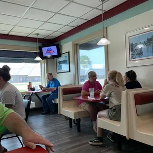 diners sitting at tables and watching tv