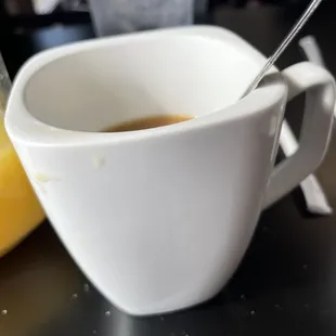 a cup of coffee and a spoon on a table