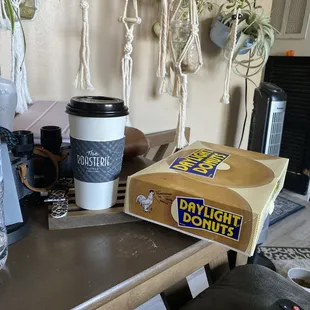 a box of doughnuts and a cup of coffee