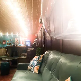 a green leather couch with pillows