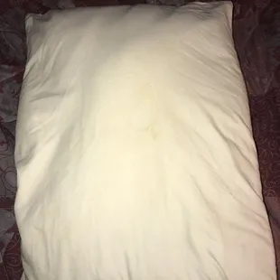 Yellow drool stains on one of the pillows with no pillow case
