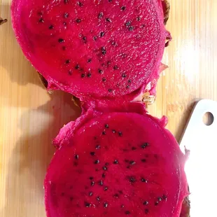 two halves of a dragon fruit on a cutting board