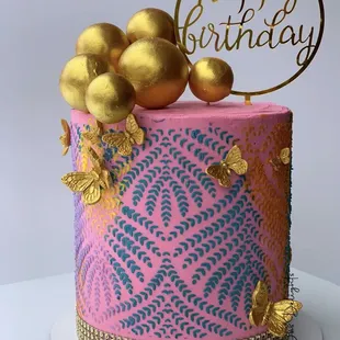 a pink and gold birthday cake