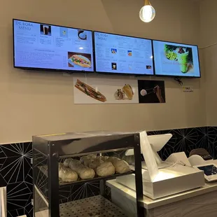 a restaurant counter with menus on the wall