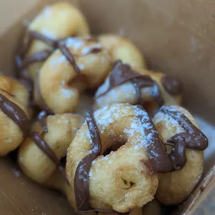Fresh mini donuts with custom toppings. Nutella and powdered sugar.