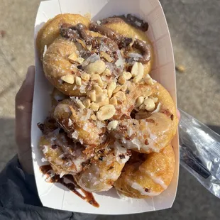 a person holding a box of donuts