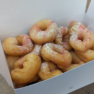Fresh mini donuts with custom toppings. Strawberry glaze and powdered sugar.