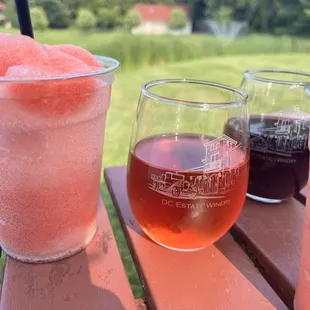three glasses of wine and a glass of watermelon