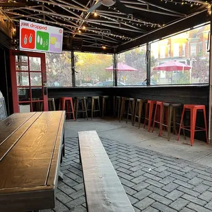 a long wooden table and red stools