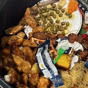 So called chicken fingers, vegetable tray, catfish, pasta dish, meatballs,  and mutant chicken wings in the TRASH