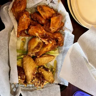 a basket of chicken wings and dips