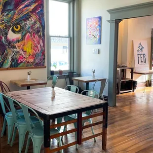 a dining room with a large painting on the wall