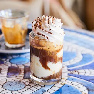 a glass of iced coffee with whipped cream