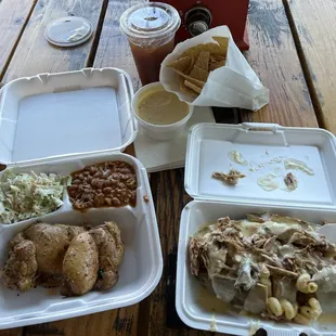 Left: Single meal plate with chicken, coleslaw, and cowboy beans. Right: Loaded baked potato with pulled pork, mac &apos;n cheese, and queso