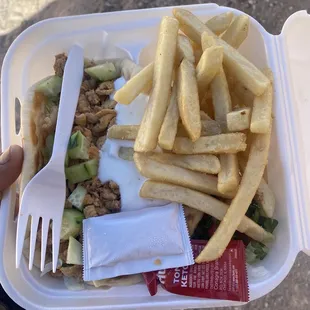 french fries and a salad in a styrofoam container
