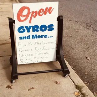 an open sign on the sidewalk